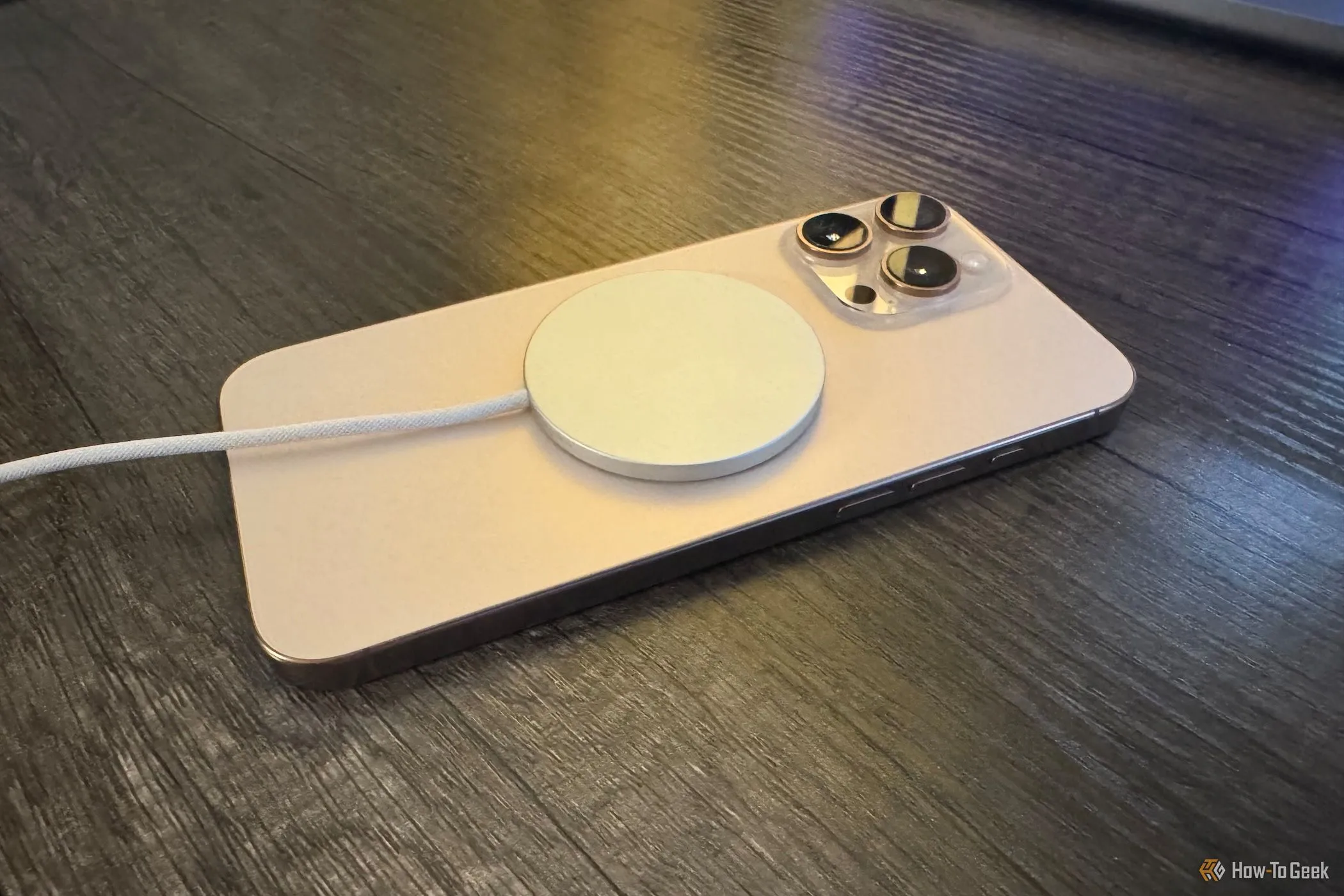 Bộ sạc Apple MagSafe gắn vào iPhone 16 Pro Max từ góc nghiêng, thể hiện sự tiện lợi của sạc không dây