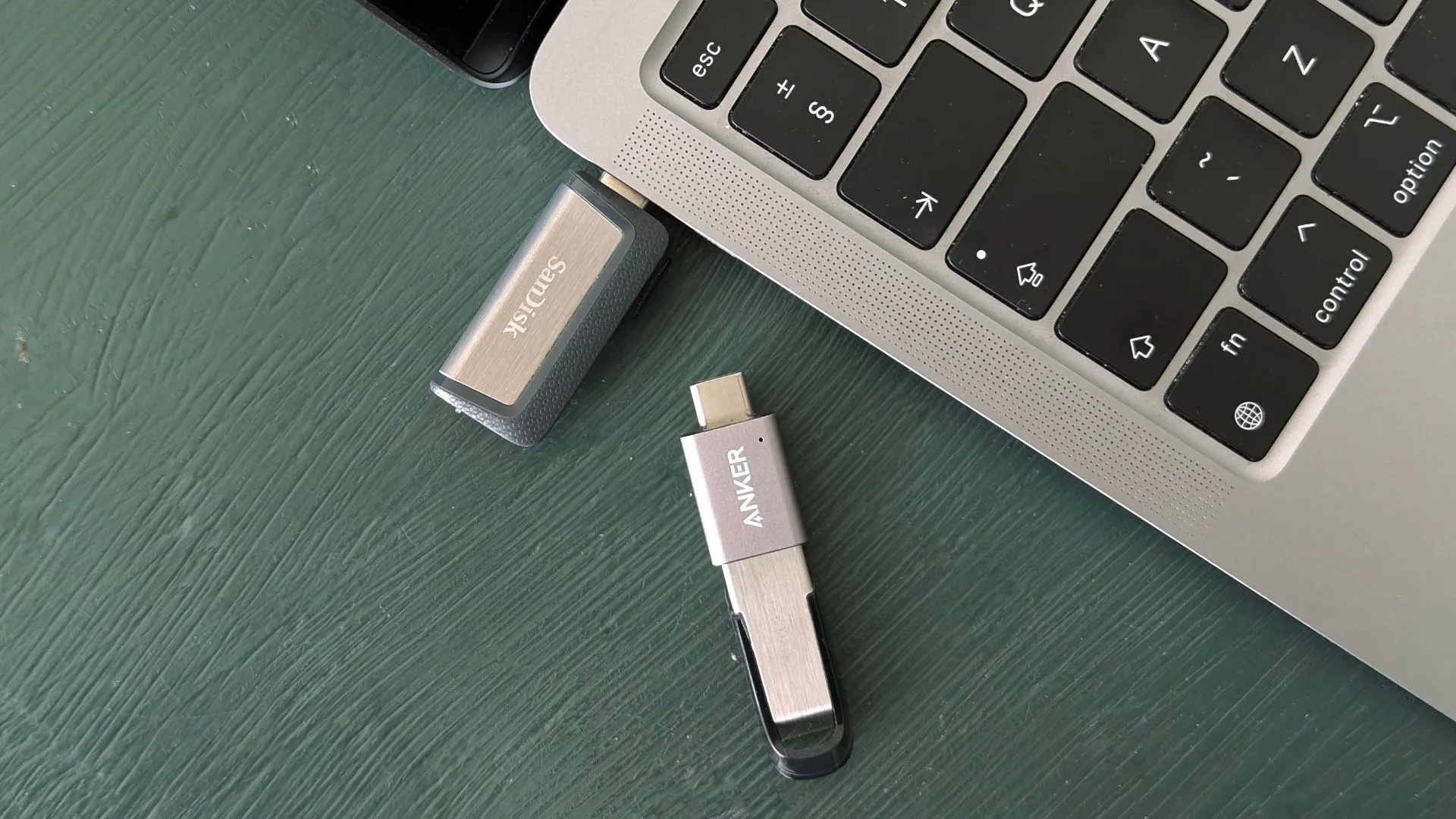 Các loại USB flash drive cạnh MacBook, minh họa sự đa dạng