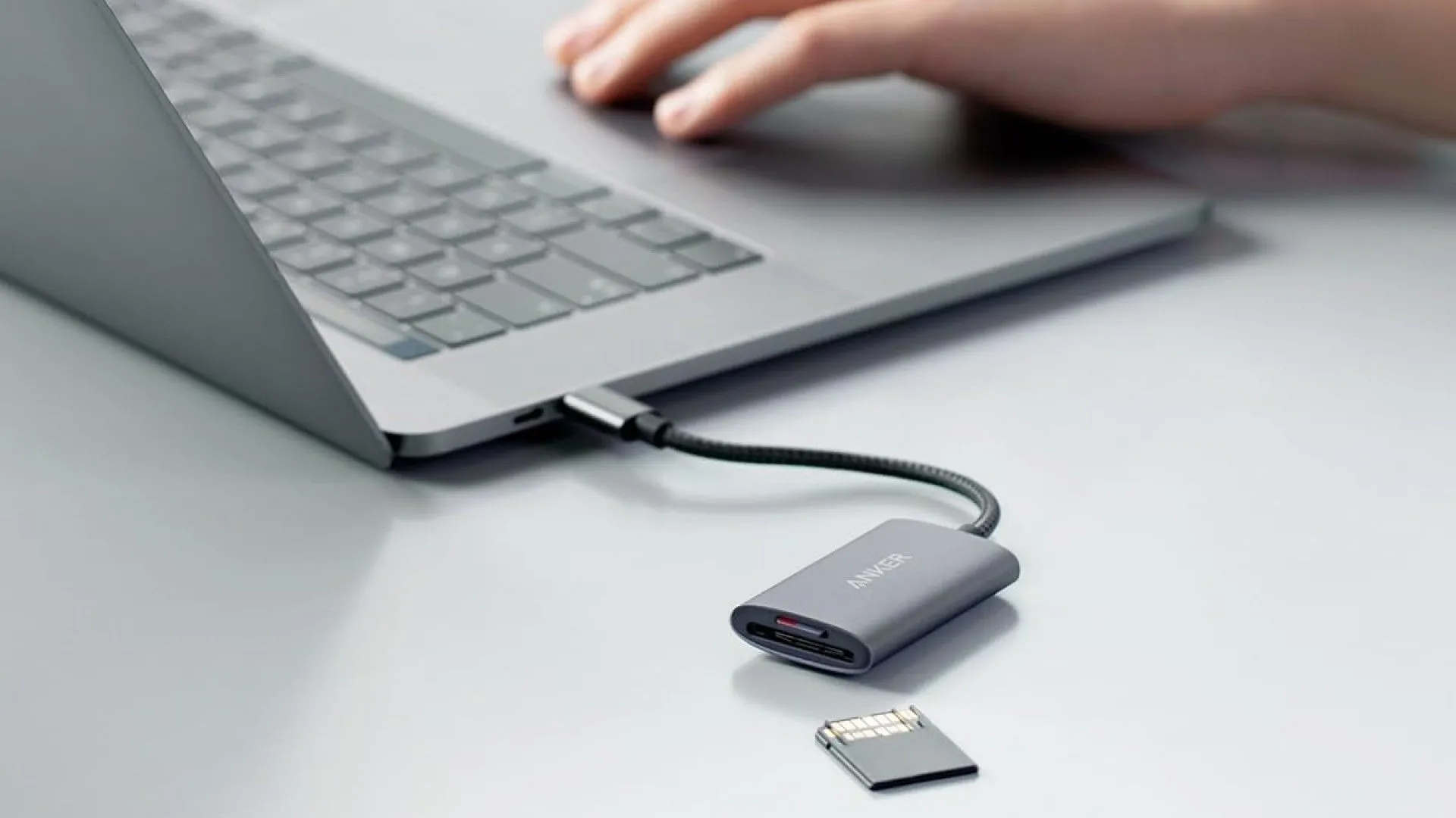 Đầu đọc thẻ SD Anker PowerExpand+ màu đen đang được cắm vào một chiếc laptop, minh họa tính năng đọc thẻ nhớ.