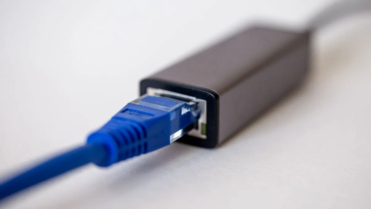 Dây cáp Ethernet được cắm vào bộ chuyển đổi USB-C, minh họa khả năng kết nối Meta Quest với mạng có dây.