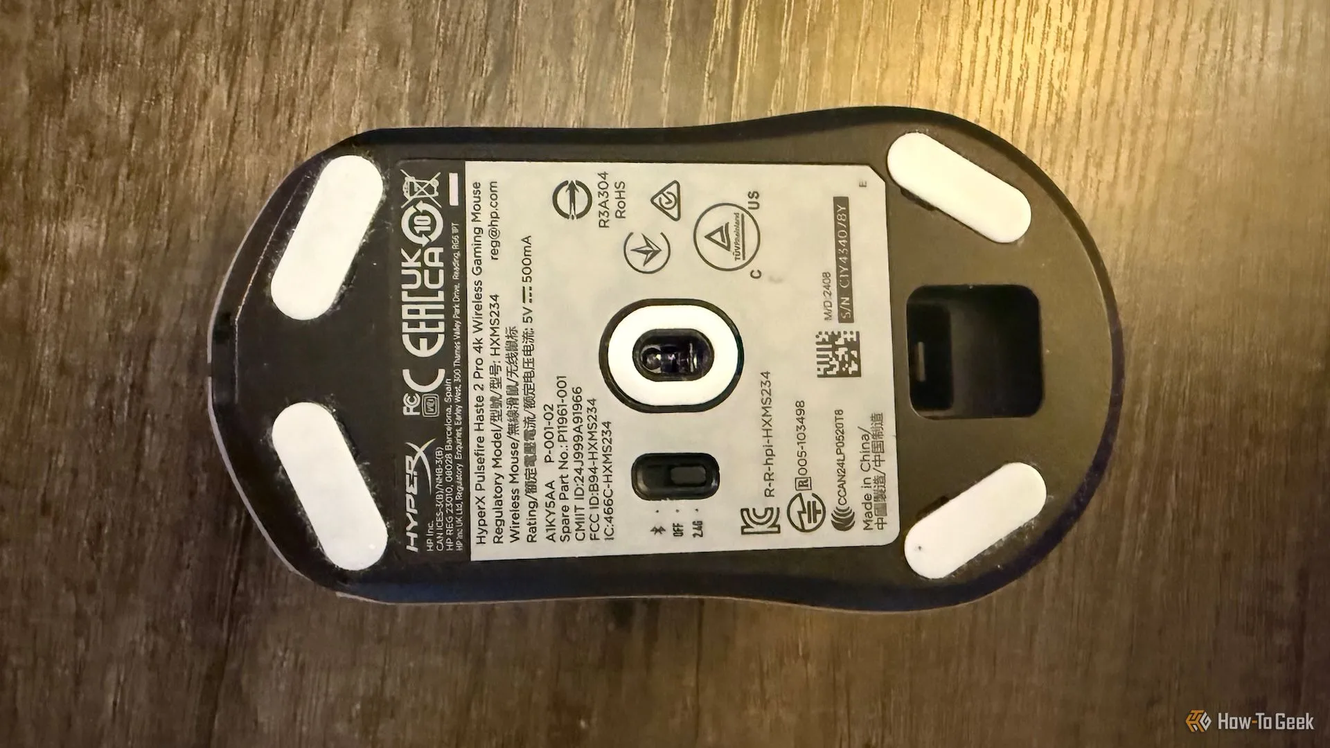 Đáy của chuột HyperX Pulsefire Saga 2 Pro với các miếng mouse skates trắng.