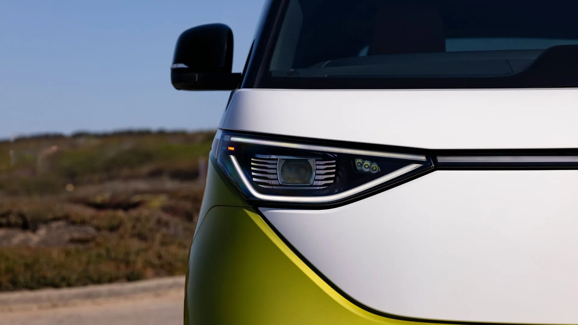Đèn pha phía trước của xe van điện Volkswagen ID. Buzz 2025 màu vàng.