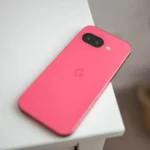 Điện thoại Google Pixel 9a đặt trên mặt bàn, hiển thị thiết kế tối giản không có cụm camera lồi.