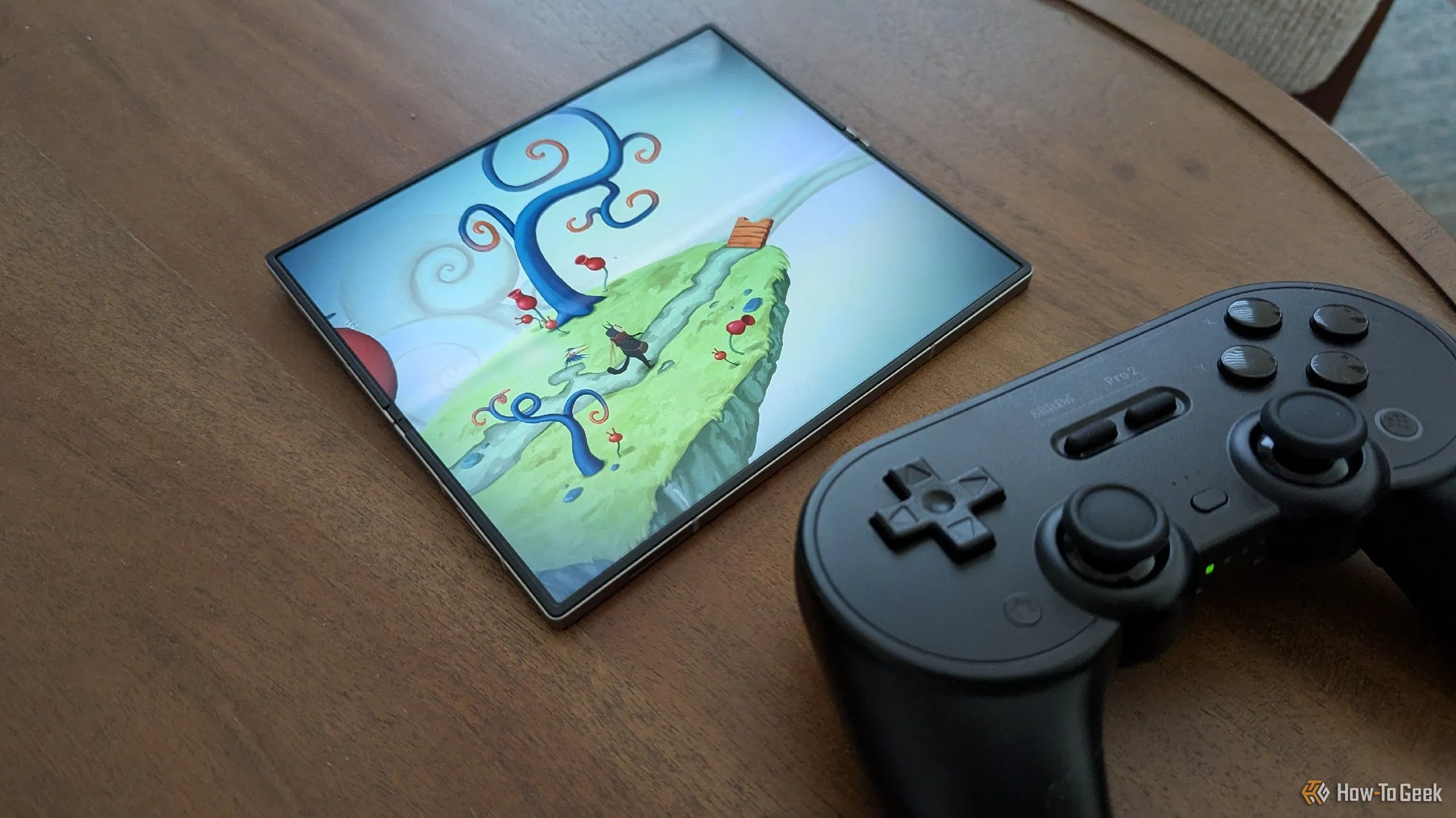 Game Figment trên Galaxy Z Fold 6 bên cạnh tay cầm 8BitDo Pro 2.