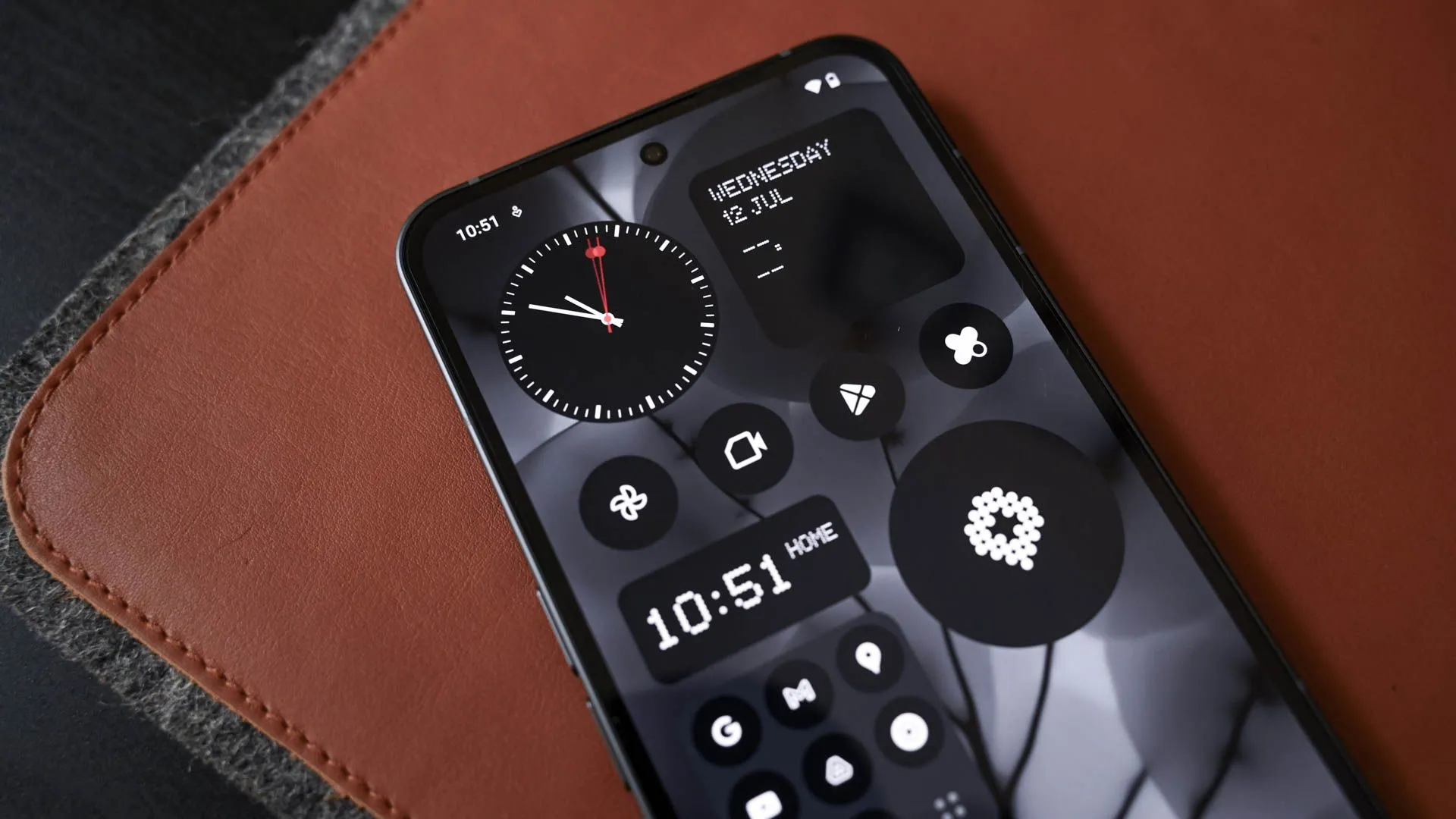 Giao diện màn hình chính của Nothing Phone (2) với các biểu tượng ứng dụng màu đen trắng đặc trưng.