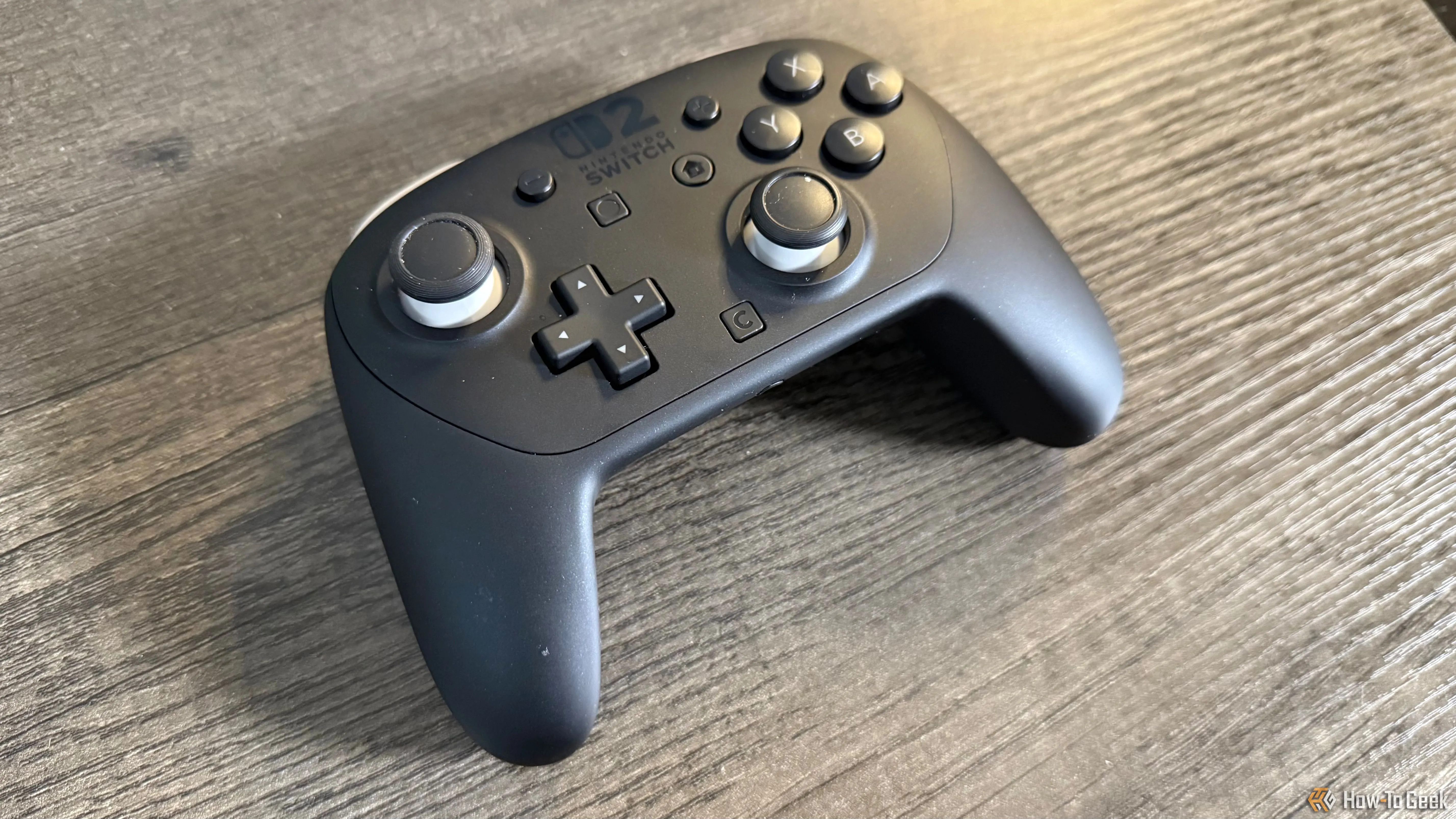 Hình ảnh tay cầm Nintendo Switch 2 Pro đặt trên mặt bàn, nhìn từ trên xuống, làm nổi bật thiết kế công thái học