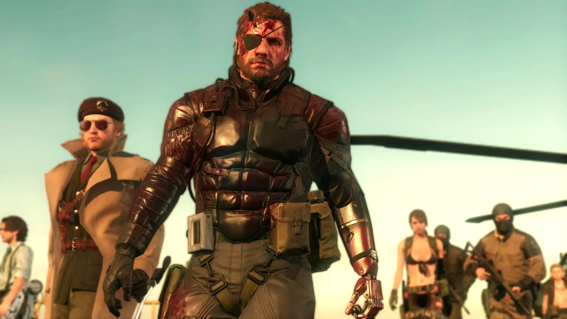 Huey Emmerich, Kazuhira Miller, Venom Snake và Quiet cùng những người lính khác đang nhìn vào màn hình trong Metal Gear Solid V: The Phantom Pain, thể hiện chiều sâu của cốt truyện gián điệp.