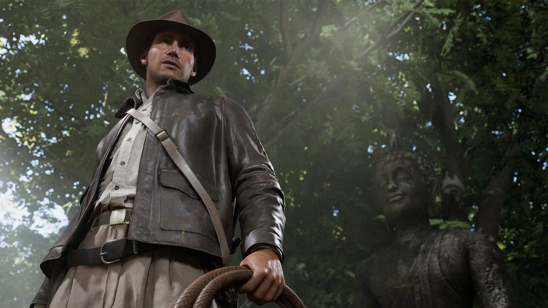 Indiana Jones đứng cạnh một bức tượng cổ trong một hang động, thể hiện tinh thần phiêu lưu.