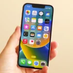 iPhone 13 mini trong tay một phụ nữ, minh họa kích thước nhỏ gọn của dòng điện thoại mini.