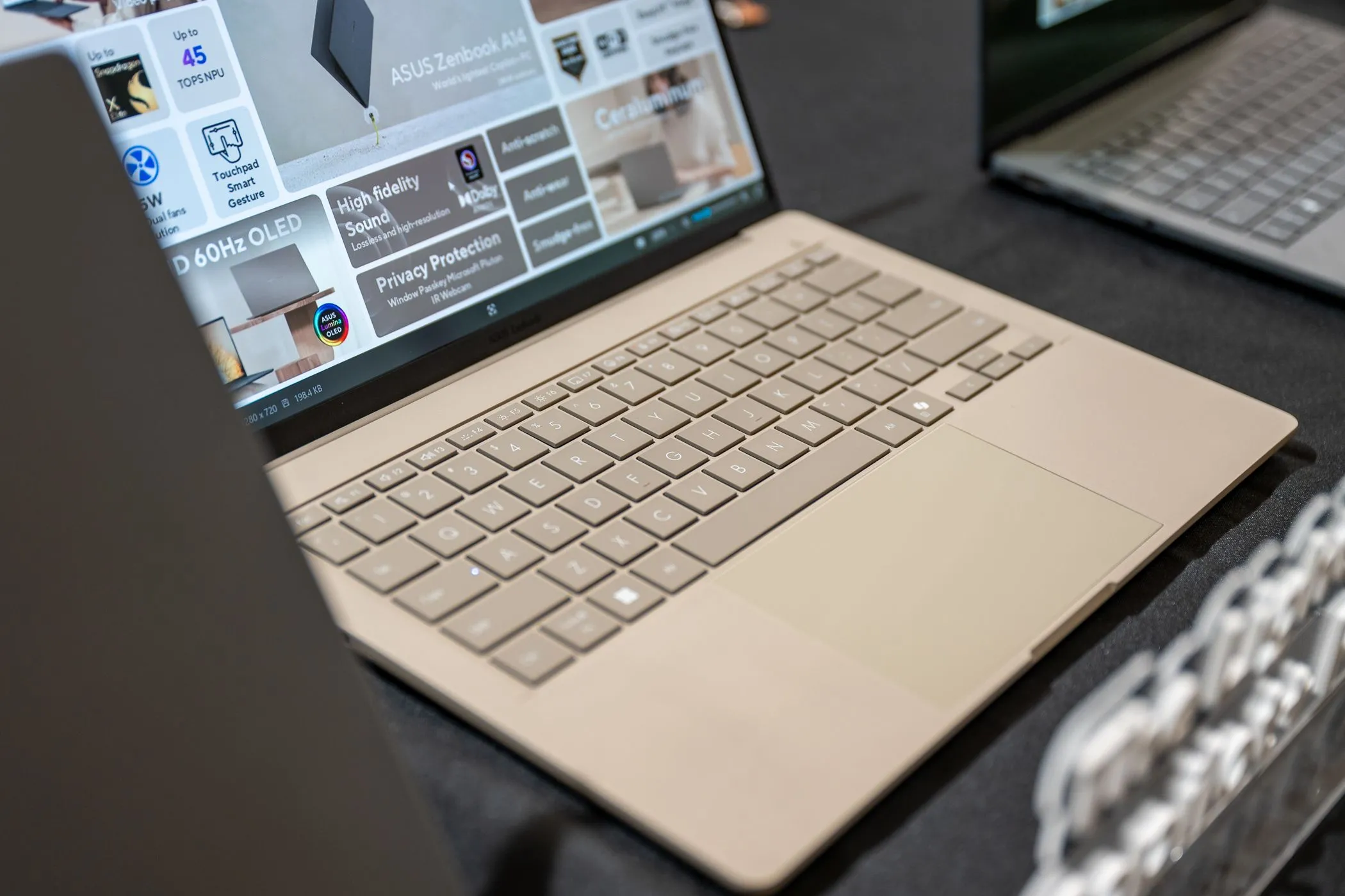 Laptop ASUS Zenbook A14 màu xám bạc với màn hình hiển thị và bàn phím rõ nét, thể hiện thiết kế mỏng nhẹ