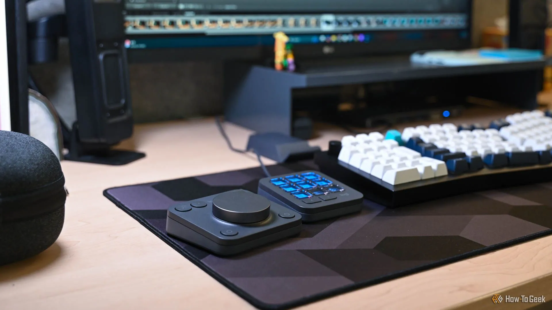 Logitech MX Creative Console đang được sử dụng trên bàn làm việc, với màn hình máy tính hiển thị ứng dụng Adobe Creative Cloud, minh họa bối cảnh sử dụng thực tế.