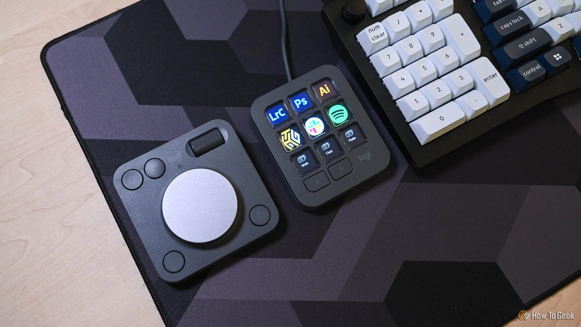Logitech MX Creative Keypad và Dialpad đặt cạnh nhau trên bàn làm việc, cho thấy sự khác biệt về kích thước và thiết kế của hai thiết bị.