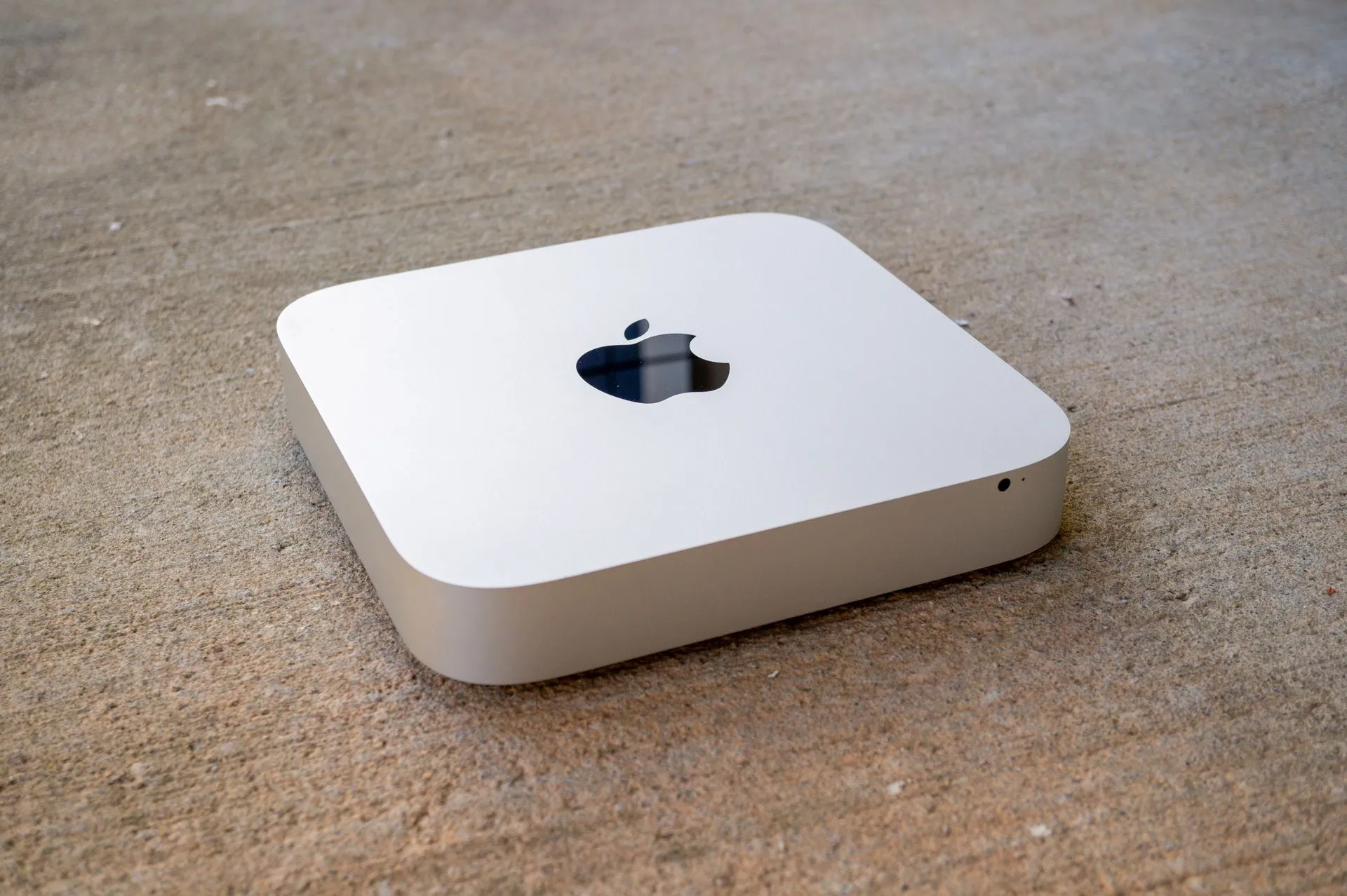 Mac Mini đặt trên bề mặt bê tông, minh họa thiết bị Apple cũ cần kiểm tra Activation Lock và MDM khi mua.