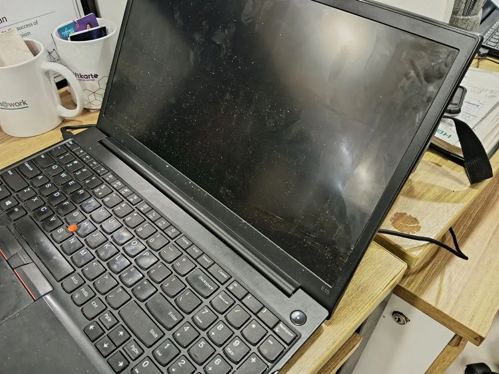Màn hình laptop bị bám đầy dấu vân tay, bụi bẩn và vết ố, thể hiện nhược điểm của màn hình cảm ứng bóng