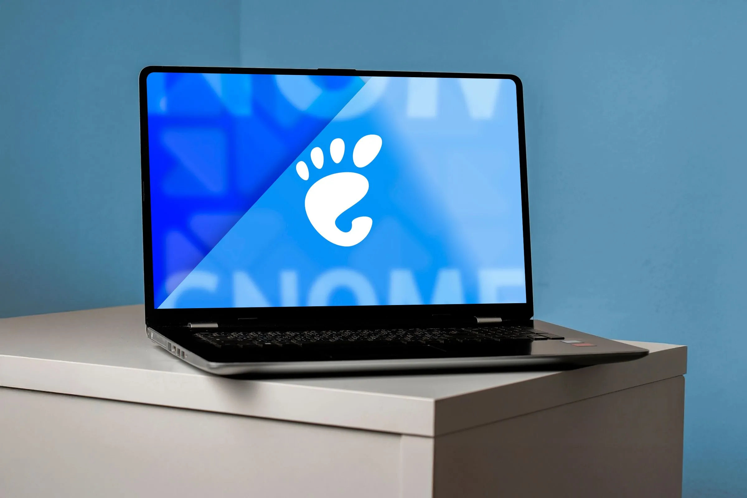 Màn hình máy tính xách tay hiển thị logo GNOME và giao diện người dùng desktop.