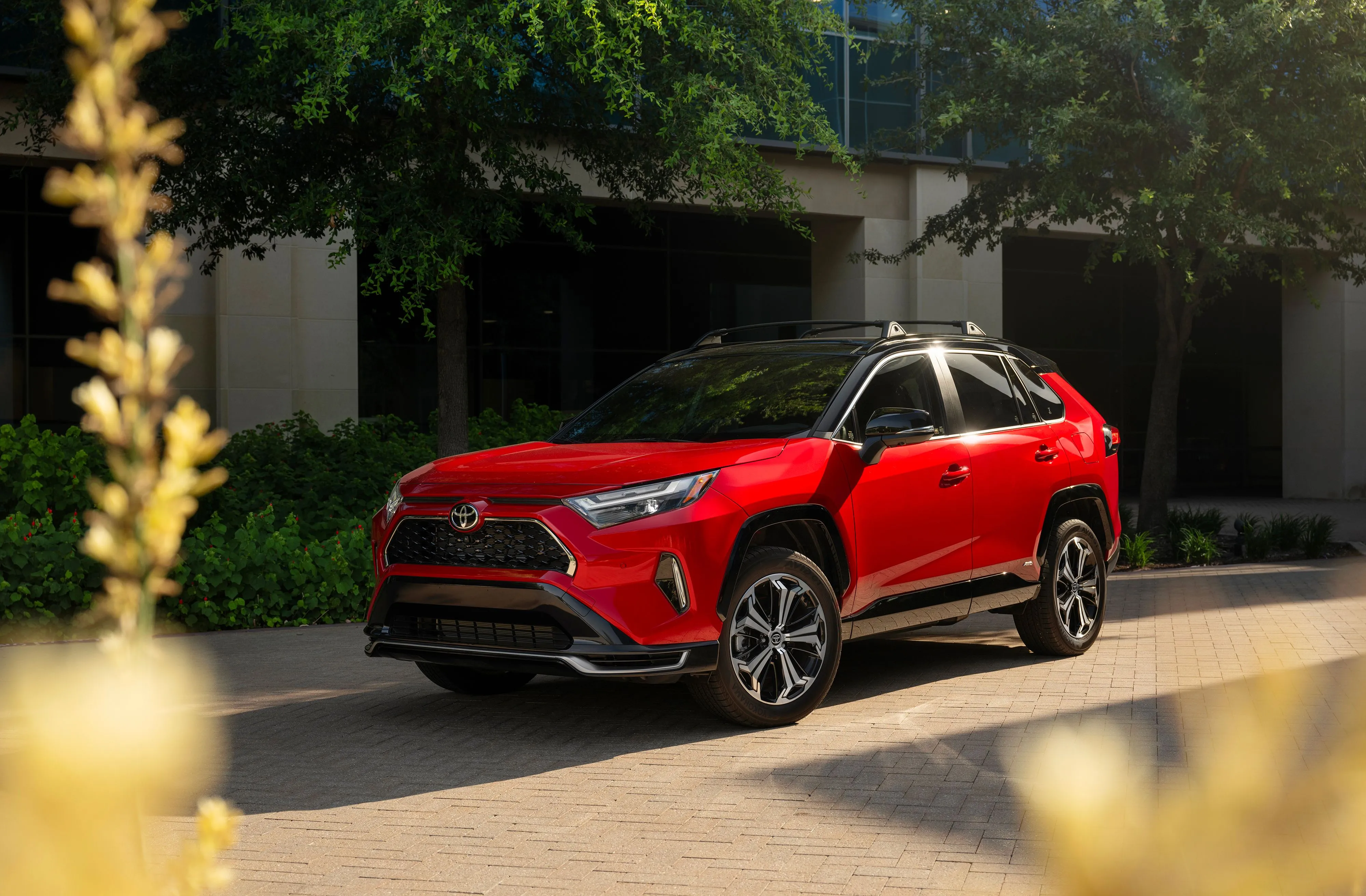 Mẫu xe Toyota RAV4 Plug-in Hybrid 2025 màu đỏ đang đỗ tĩnh.