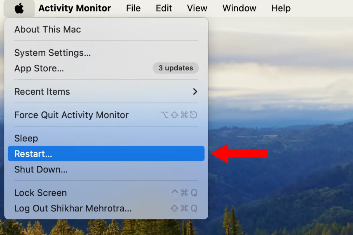 Menu Apple với mũi tên chỉ vào tùy chọn Khởi động lại trên macOS