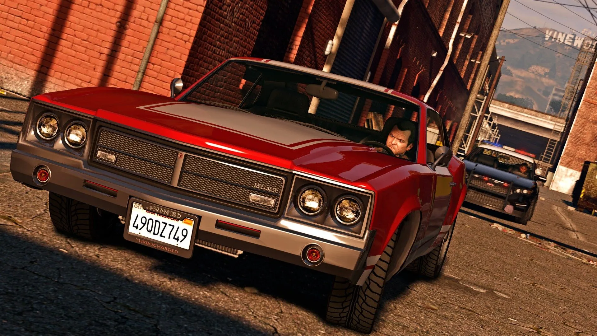 Michael đang lái xe ô tô cố gắng thoát khỏi cảnh sát trong Grand Theft Auto V, trên một con đường đô thị.