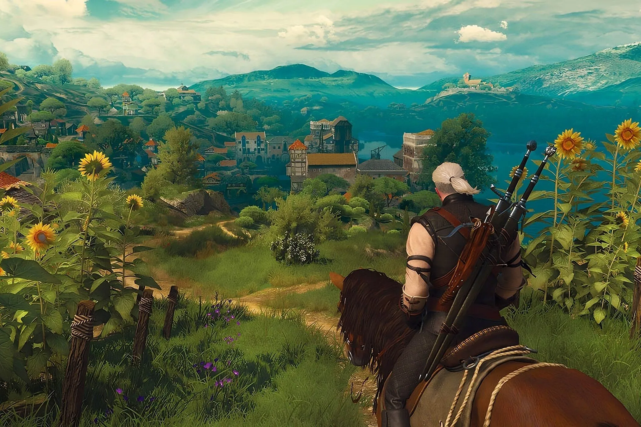 Một cảnh quay quảng cáo từ The Witcher 3, với nhân vật chính Geralt đứng trên một vách đá nhìn ra cảnh quan rộng lớn.