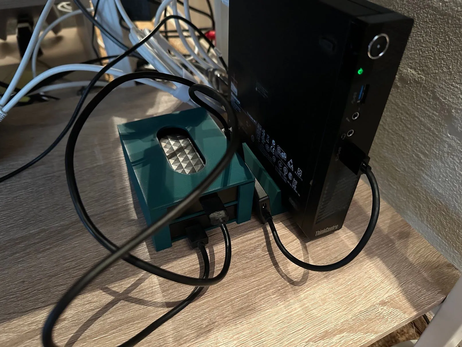 Một mini-PC được dùng làm Plex server, kết nối với giá đỡ máy in 3D và khay ổ cứng ngoài, cho thấy giải pháp lưu trữ media.