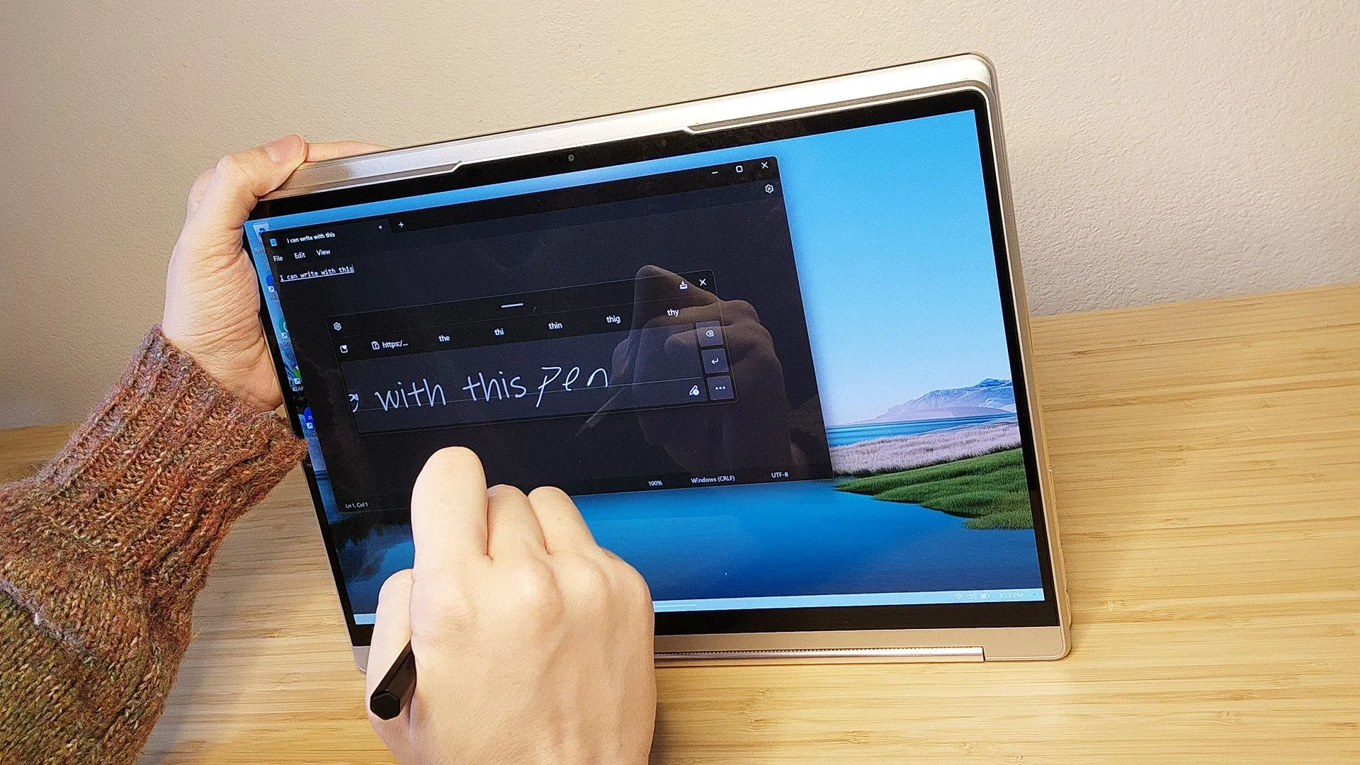 Một người đang viết hoặc vẽ trên màn hình của chiếc laptop Lenovo Yoga 9i Gen 8 bằng bút stylus đi kèm, minh họa việc sử dụng cho công việc sáng tạo
