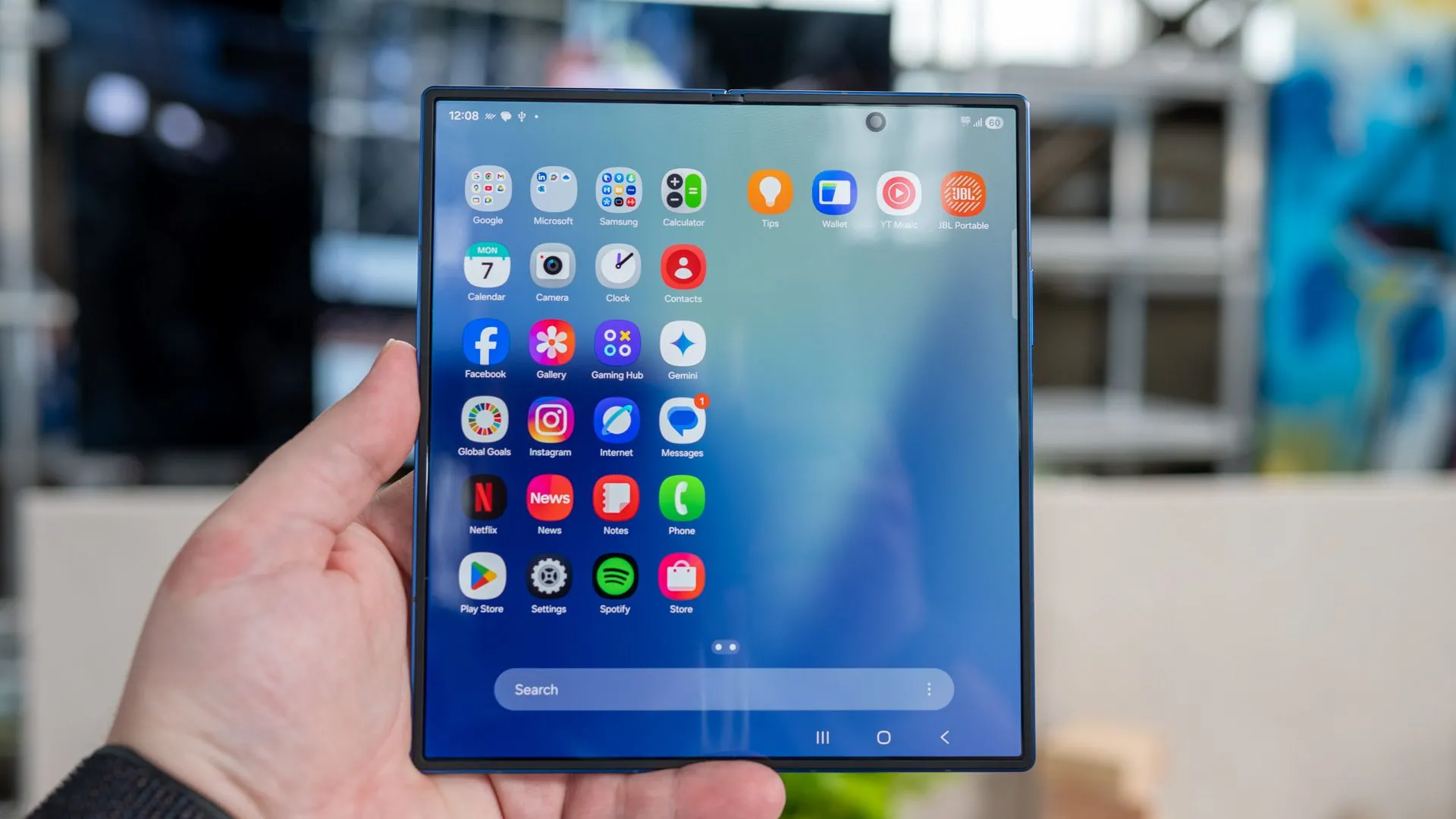 Người dùng cầm Samsung Galaxy Z Fold 7 đang mở, hiển thị ngăn kéo ứng dụng trên màn hình bên trong với camera đục lỗ nổi bật