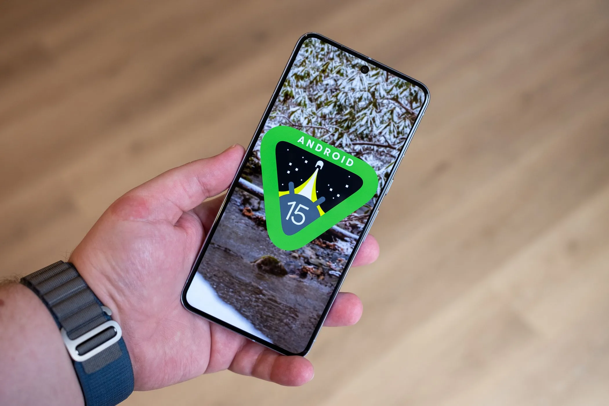 Người dùng đang cầm chiếc Google Pixel 8 Pro hiển thị logo Android 15 trên màn hình, tượng trưng cho chính sách cập nhật phần mềm mới của Google.