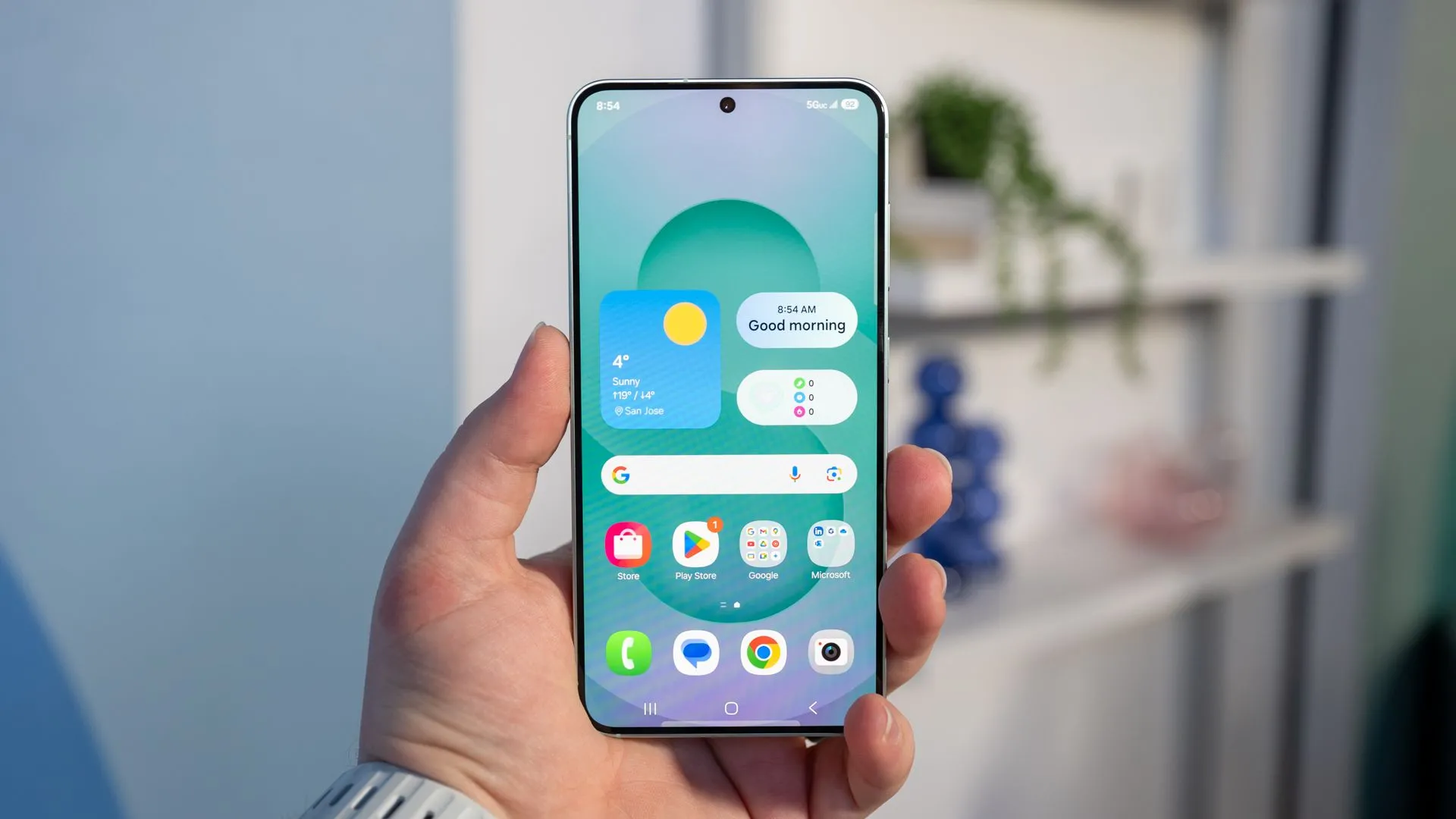 Người dùng đang cầm chiếc Samsung Galaxy S25 và nhìn vào màn hình hiển thị