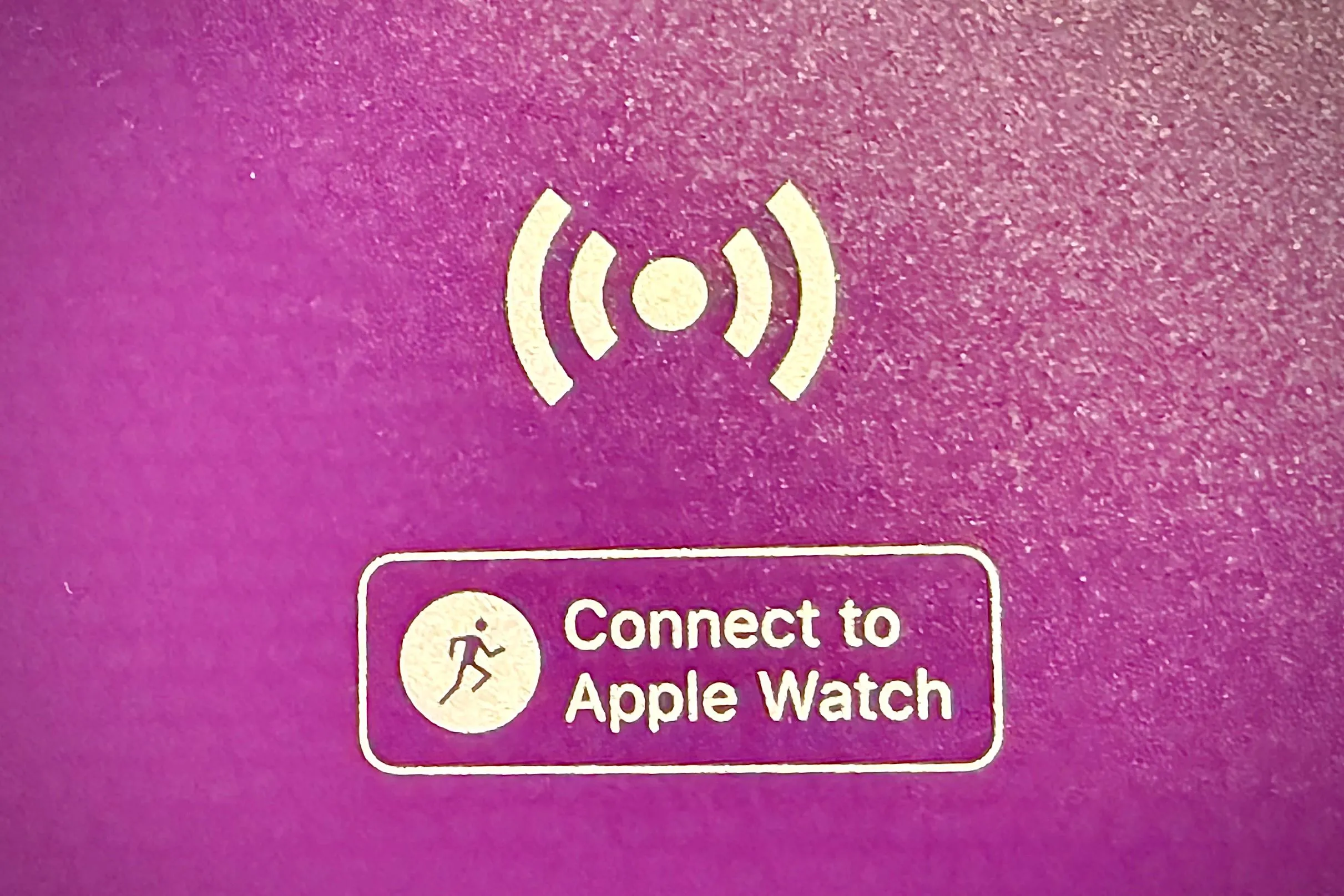 Người dùng giữ Apple Watch gần khu vực NFC để kết nối với thiết bị tập gym.