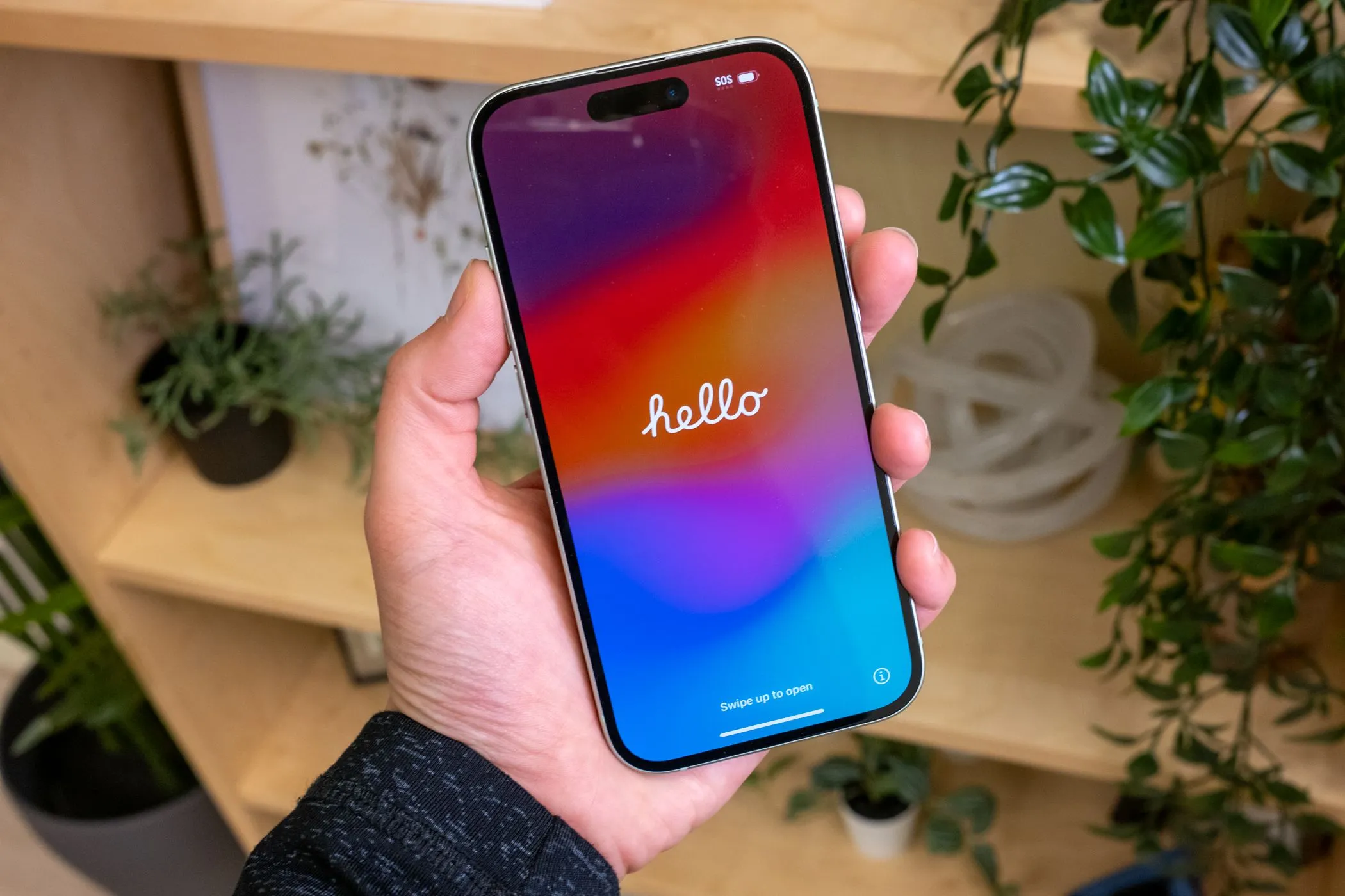 Người dùng trải nghiệm màn hình Super Retina XDR sáng rõ của iPhone 15 màu xanh