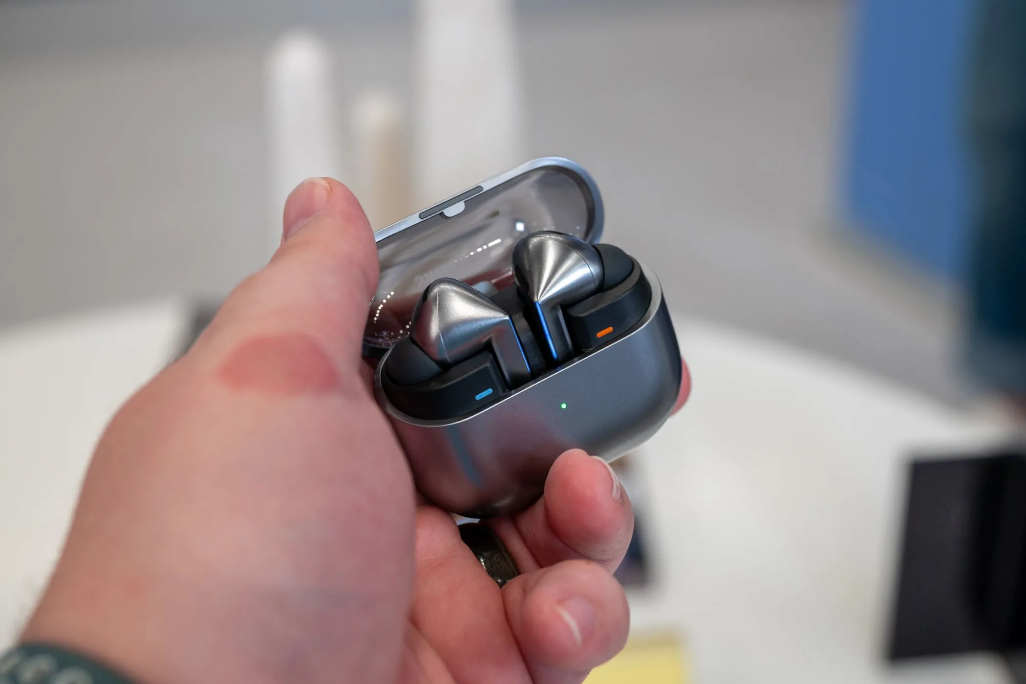 Tai nghe Samsung Galaxy Buds 3 Pro màu bạc được đặt trong hộp sạc trong suốt đang mở, hiển thị thiết kế và vị trí đặt tai nghe.