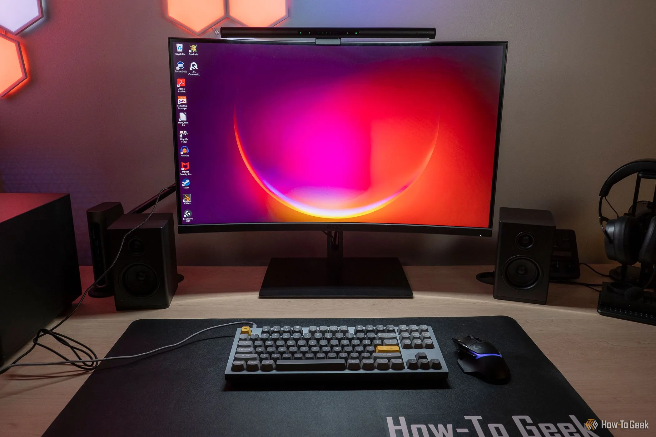 Thanh đèn màn hình Razer Aether chiếu sáng một chiếc bàn làm việc hiện đại với màn hình tỷ lệ 16:9, thể hiện sự phát triển của công nghệ màn hình.
