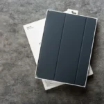 Vỏ bảo vệ iPad Smart Folio màu đen được đặt trong hộp, minh họa cho việc sử dụng nam châm trong cảm biến ngủ/thức.