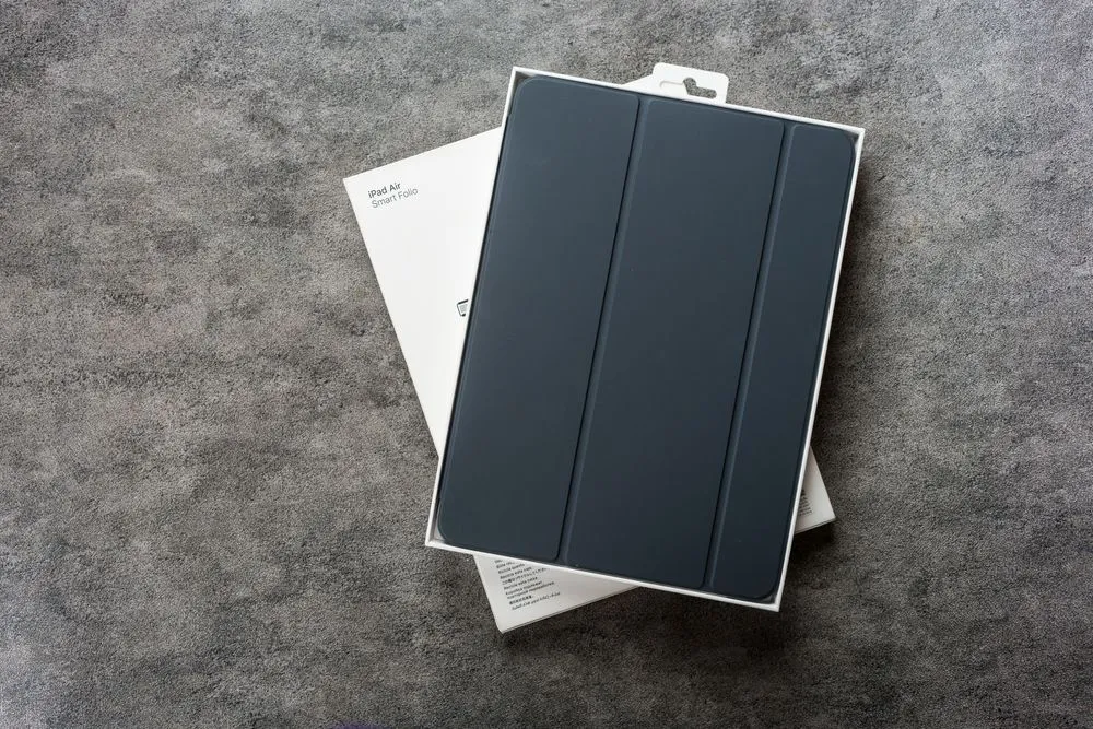Vỏ bảo vệ iPad Smart Folio màu đen được đặt trong hộp, minh họa cho việc sử dụng nam châm trong cảm biến ngủ/thức.