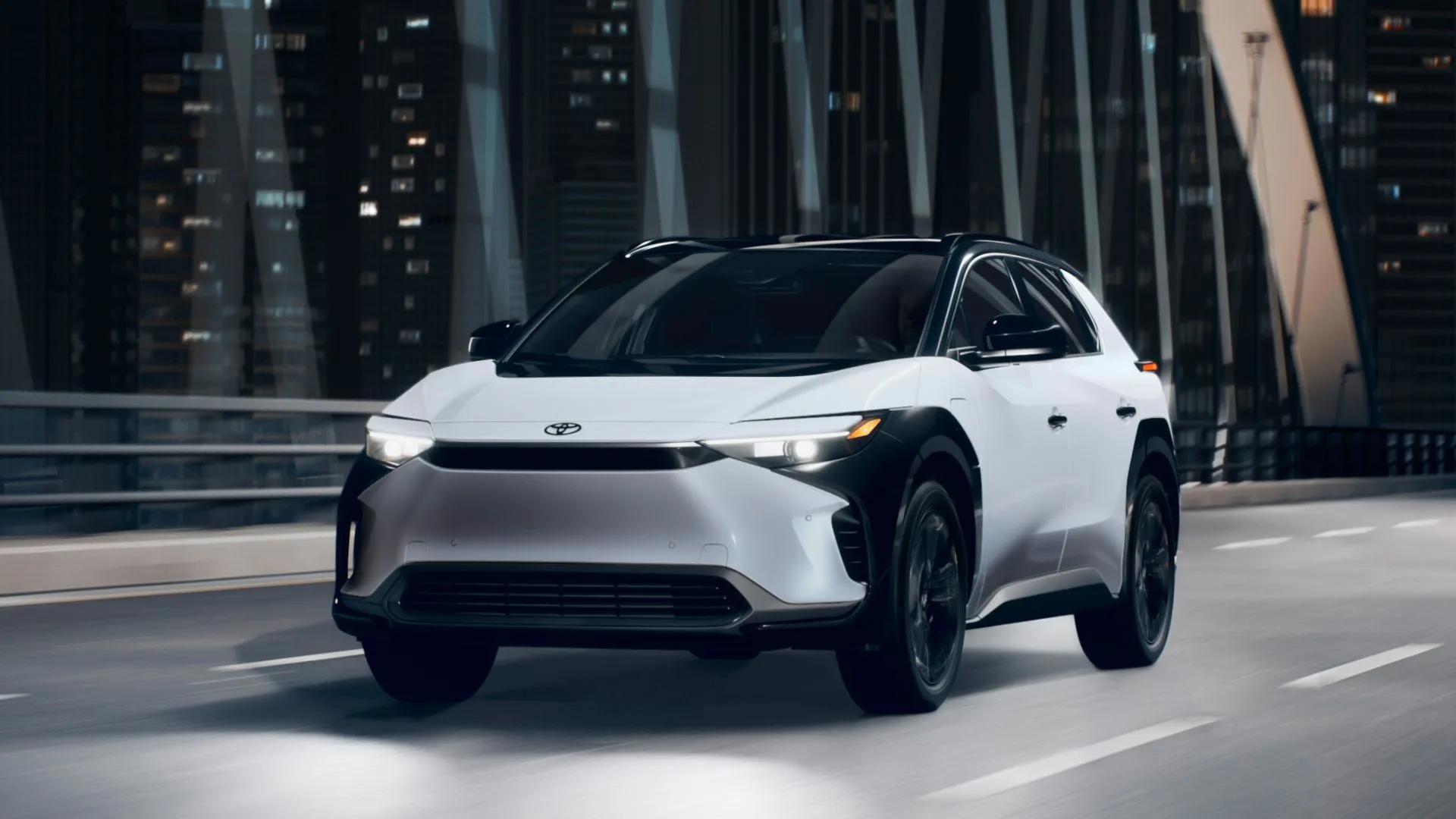 Xe Toyota bZ4X 2025 màu trắng đang lái trên cầu vào ban đêm.
